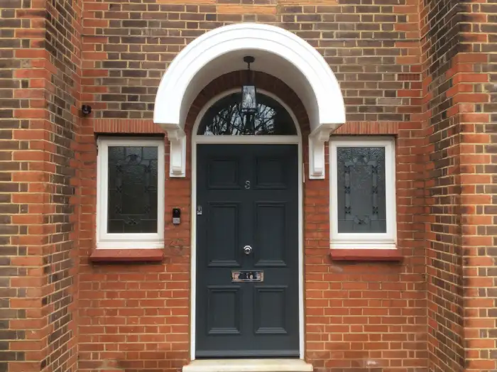 A custom-made rounded door canopy, made to fit a door with a half-moon window above it