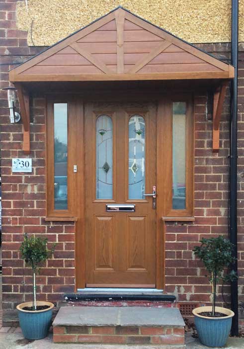 A brown wooden and UPVC door canopy installed on a house in the UK
