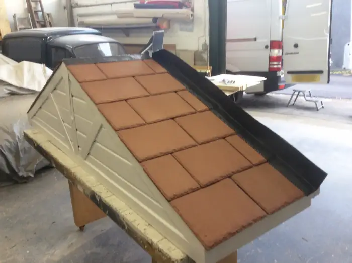 A door canopy roof being custom-made, with high-quality long-lasting red composite roof tiles.